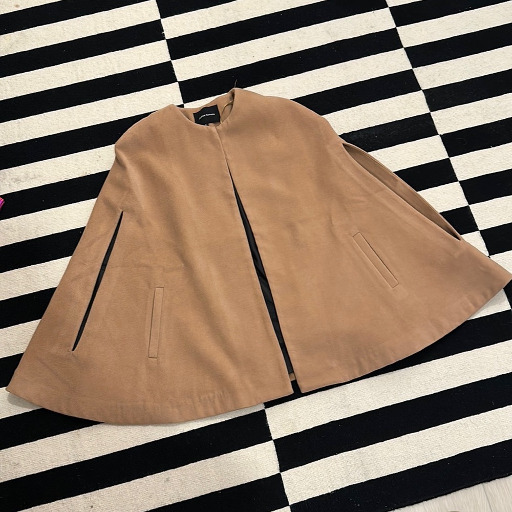 Beige cape with pockets. In great condition. Clasp at the neck.